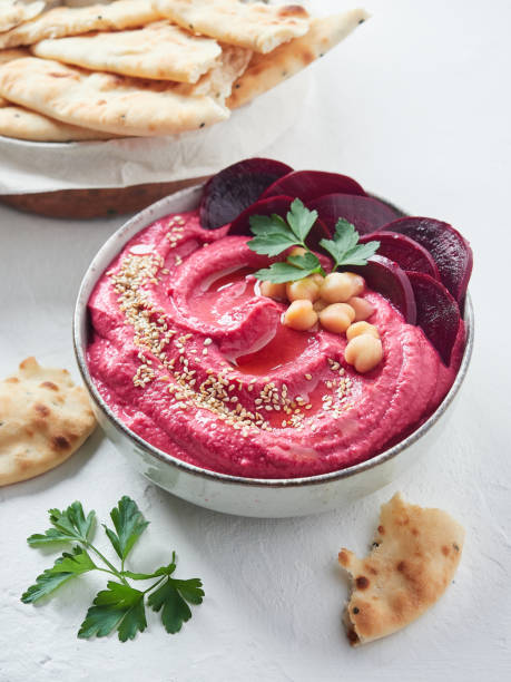 istock beetroot hummus in a bowl garnished with sesame seeds, beet slices, chickpeas, parsley and olive oil. Served with pita bread. 1461369582