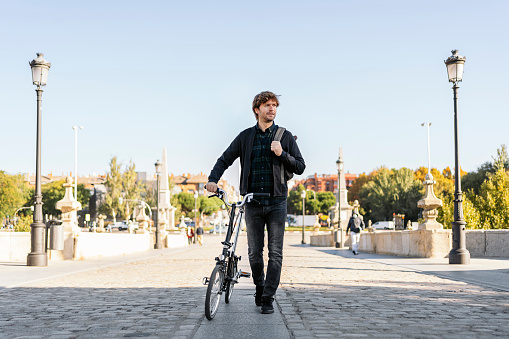 Stock photo of handsome man using his detachable bike during sunny day.