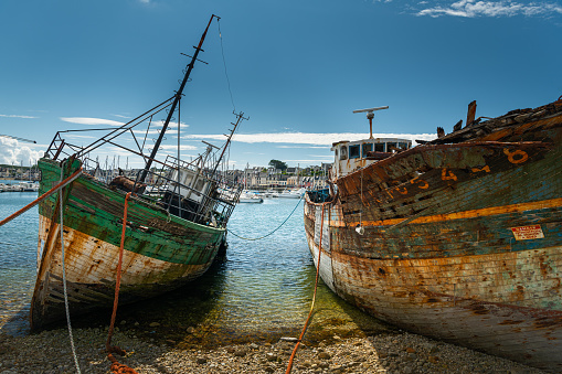 Camaret-sur-Mer, France - August, 20 2020: Old rusty boats in the boat cemetery, sunny day in summer