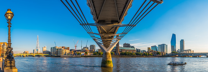 Panoramic view across the River Thames beneath the Millennium Bridge to the South Bank.