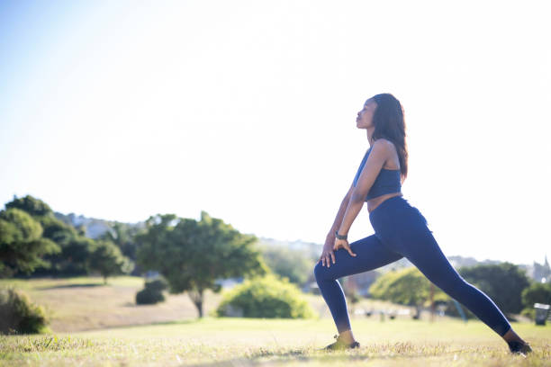 istock Side view woman with eyes closed doing lunges stretching in park 1461373065