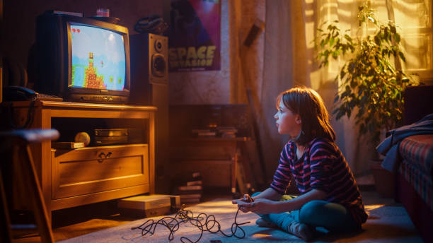 istock Adorable Child Playing Eight Bit Arcade Video Game on a Console at Home in Her Room with Eighties Interior. Young Girl Reaches End of Level and Wins. Nostalgic Retro Childhood Concept. 1461374193