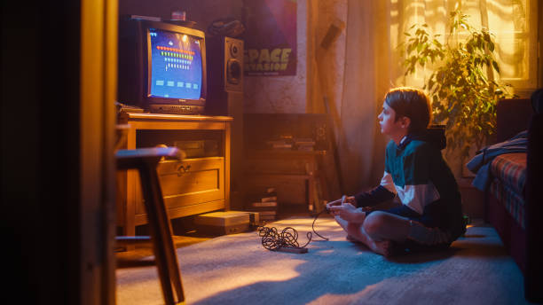 istock Handsome Child Playing 2D Arcade Space Shooter Video Game on a Console at Home in His Room with Eighties Interior. Young Boy Reaches End of Level and Wins. Nostalgic Retro Childhood Concept. 1461374755