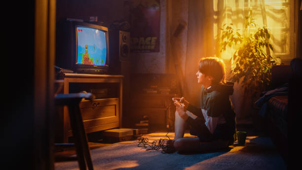 istock Handsome Child Playing Eight Bit Arcade Video Game on a Console at Home in His Room with Eighties Interior. Young Boy Reaches End of Level and Wins. Nostalgic Retro Childhood Concept. 1461374791