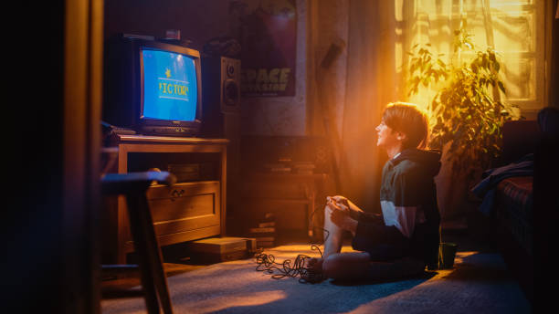 istock Handsome Child Playing Eight Bit Arcade Video Game on a Console at Home in His Stylish Room with Eighties Interior. Young Boy Reaches End of Level and Wins. Nostalgic Retro Childhood Concept. 1461374822