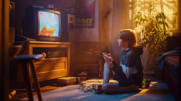 istock Nostalgic Retro Concept: Young Boy Playing Old-School Eighties Arcade Video Game on a Console at Home in His Room with Period-Correct Interior. Successful Kid Passes the Level and Wins. 1461375995