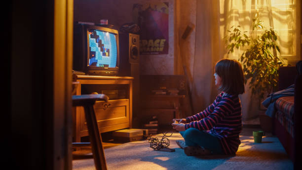 istock Nostalgic Retro Concept: Young Girl Playing Old-School Nineties Arcade Video Game on a Console at Home in Her Vintage Room with Period-Correct Interior. Kid Passes the Level with Flying Colors. 1461376109