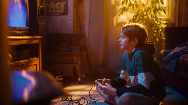 istock Young Boy Playing Eighties 2D Arcade Space Shooter Video Game on a Gaming Console at Home in His Room with Old-School Interior. Child Successfully Wins the Level. Nostalgic Retro Childhood Concept. 1461377003
