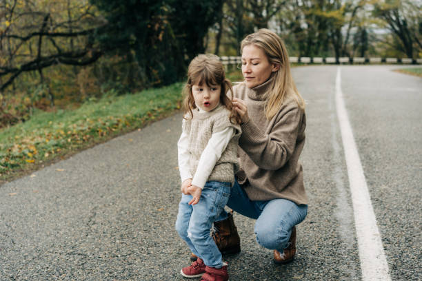 mama zaplata włosy uroczej małej córeczki na spacerze po okolicy. - affectionate baby beauty blond hair zdjęcia i obrazy z banku zdjęć