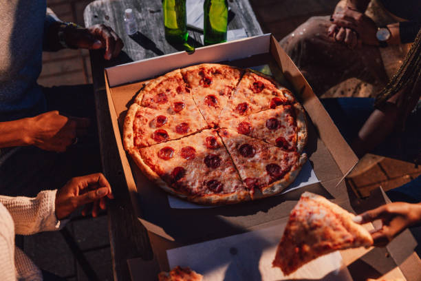 istock Friends eating pepperoni pizza on a party 1461378301