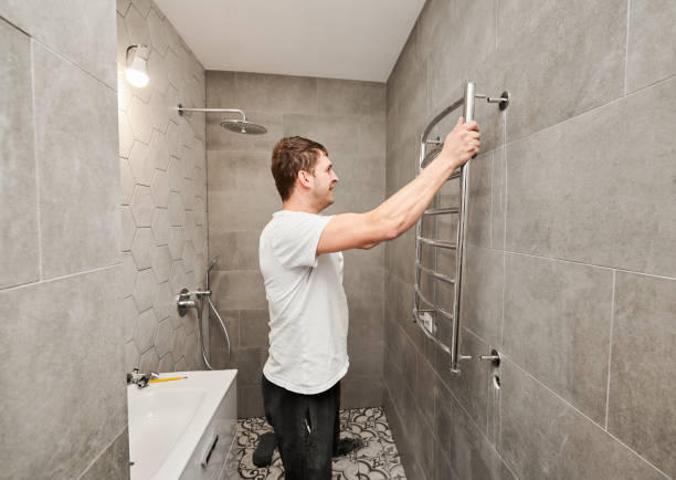 istock Man installing electric towel rack dryer in bathroom. 1461380501