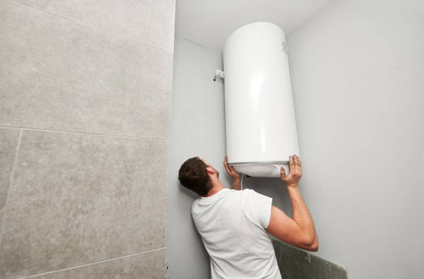 Man installing boiler water heater in apartment. stock photo