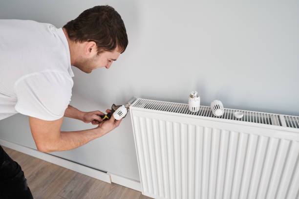 istock Man installing heating radiator in apartment under renovation. 1461380695