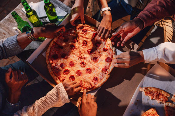 istock Friends eating pepperoni pizza on a party 1461385426
