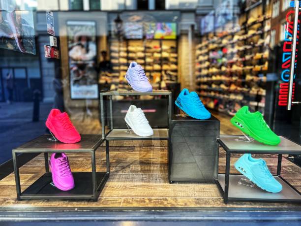 multi coloured trainers in shoe store window - shoe store shoe shopping retail imagens e fotografias de stock