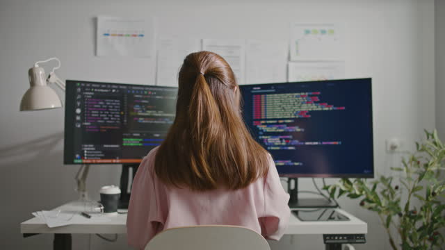 Program developer is Code Programming on her computer at office