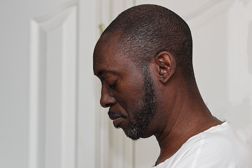 A portrait of a black man praying