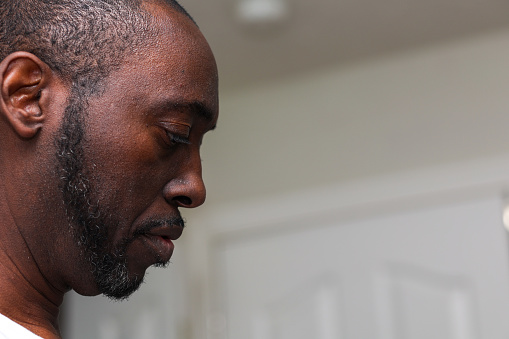 A portrait of a black man praying