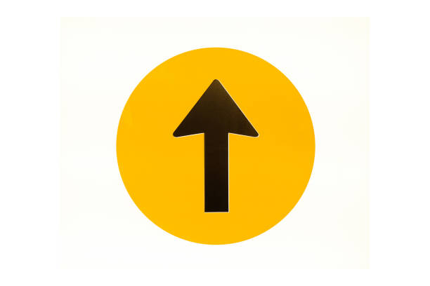 istock Black arrow sign in yellow circle on bright plate 1461404512