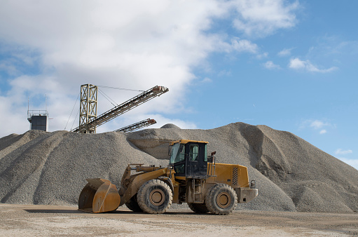 Belt conveyors, piles of rubble and Wheel loader in Gravel Quarryin sunny day