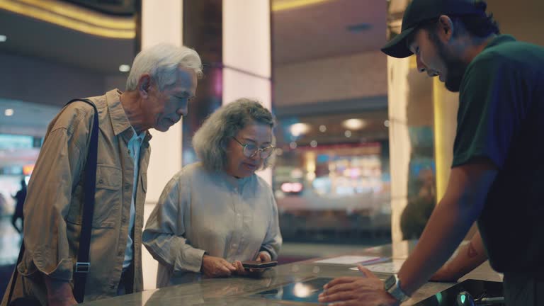 Happy senior couple buying tickets at the movies.