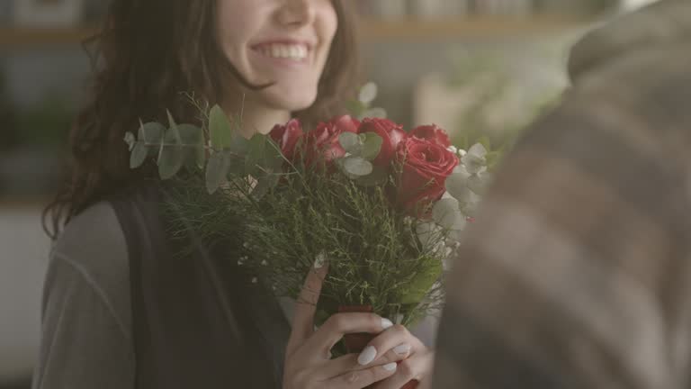 Young man gives a bouquet of roses to his girlfriend