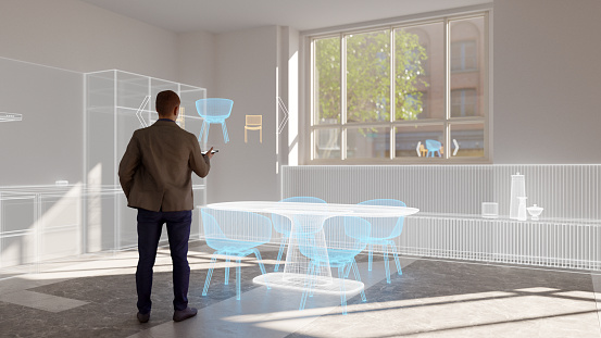 Person using augmented reality mobile application to visualize furniture in a 3D layout of a domestic kitchen. All objects in the scene are 3D