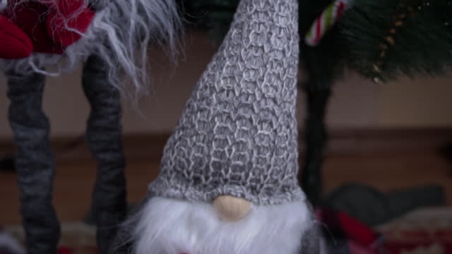 New Year's Scandinavian Gnome Stands Near the Christmas Tree
