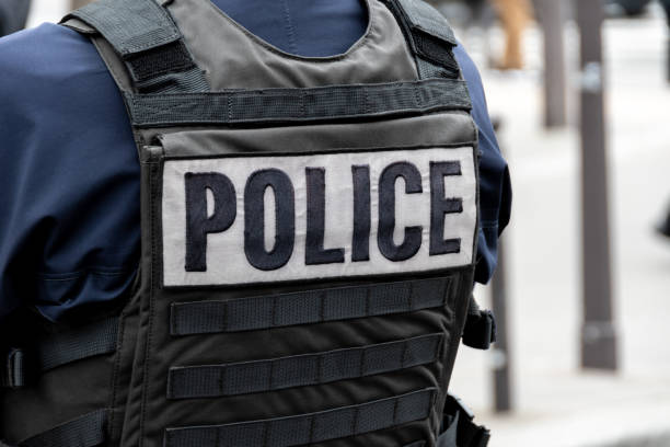 Close-up 'POLICE' marking written on the back of a bulletproof vest worn by a French police officer Close-up 'POLICE' marking written on the back of a bulletproof vest worn by a French police officer on a street in Paris, France. Concepts of law enforcement, crime, delinquency and criminal affairs police force stock pictures, royalty-free photos & images
