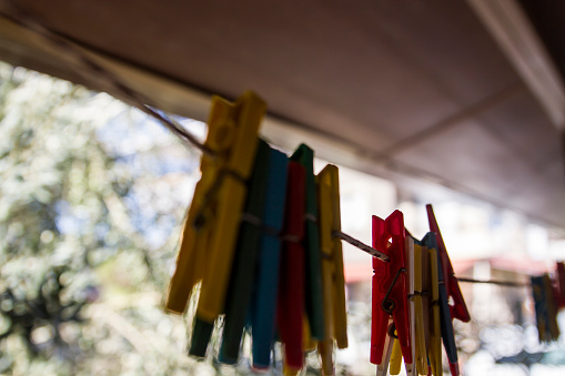 Colorful Plastic Pegs Hanging On Rope