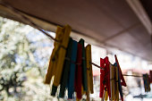 Colorful Plastic Pegs Hanging On Rope