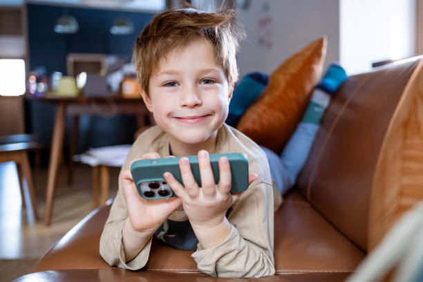 Kid using smartphone at home stock photo