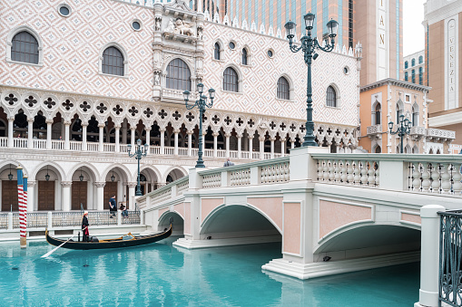 A gondolier rows at the The Venetian Casino in Las Vegas, Nevada, USA on a cloudy day.