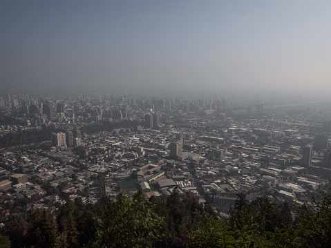 Aerial panorama of Santiago de Chile cityscape in dense fog haze smog air pollution from Cerro San Cristobal South America