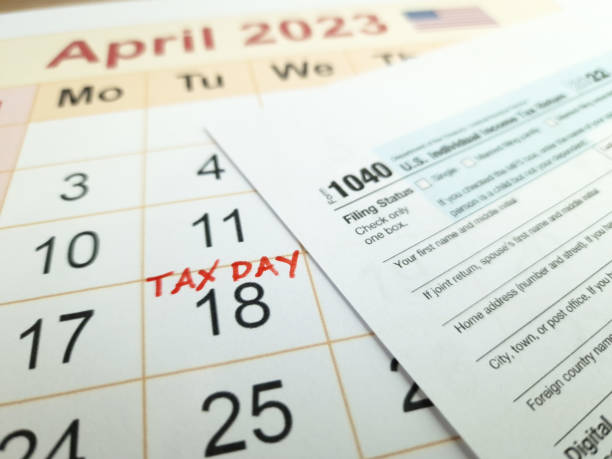 día de pago de impuestos marcado en un calendario - 18 de abril de 2023 con el formulario 1040 - número 18 fotografías e imágenes de stock
