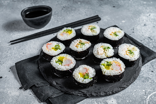 Korean style sushi Kimbap or gimbap made from steamed white rice. Gray background. Top view.