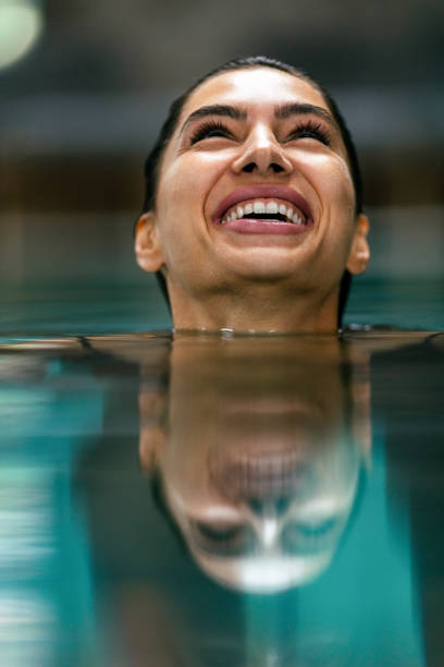 istock Beautiful young woman relaxing on indoors poolside 1461421558