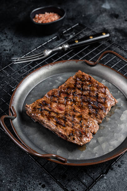 istock Alternative choice steak - Grilled Skirt or Machete beef meat.  Black background. Top view 1461423716
