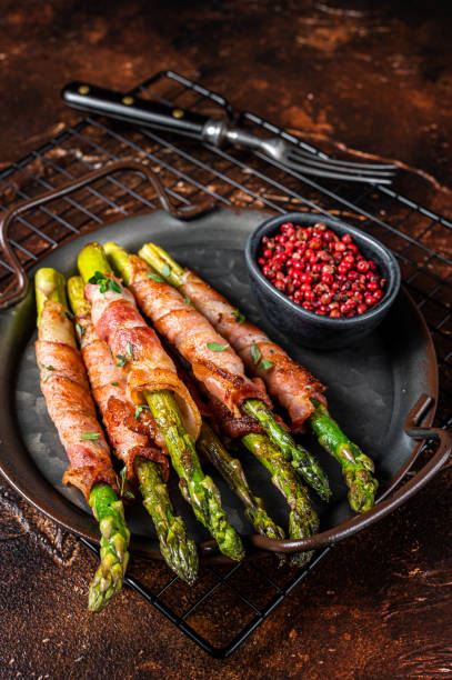 istock Baked Prosciutto wrapped green asparagus. Dark background. Top view 1461423765