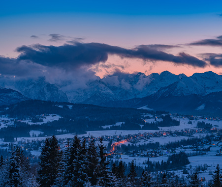 beautiful sunset over the Tatras, there are some clouds, the town at the foot of the mountains begins the evening, the lights are on, the Tatras are looking at everything