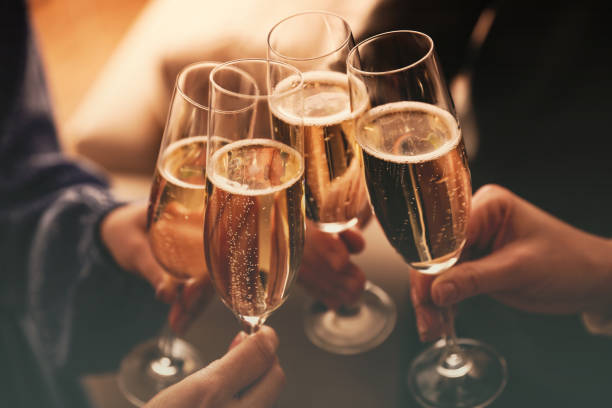 People clinking glasses with sparkling wine indoors , closeup stock photo