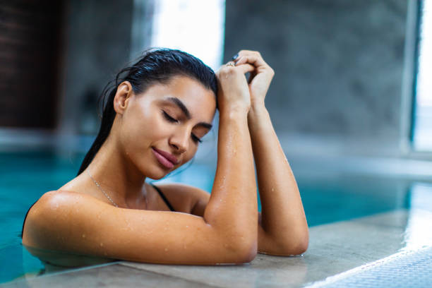 istock Beautiful young woman relaxing on indoors poolside 1461427589