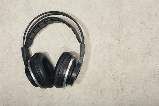 Wireless headphones flat lay on concrete background