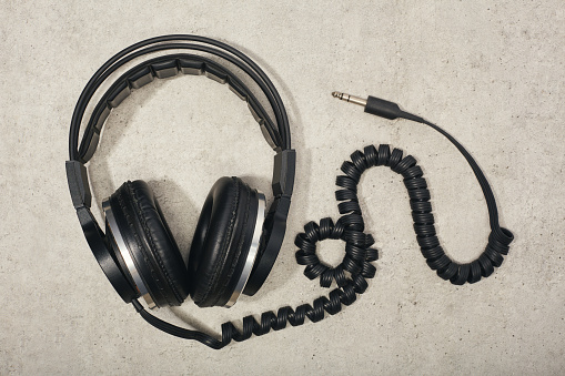 Old style vintage headphones flat lay on concrete background