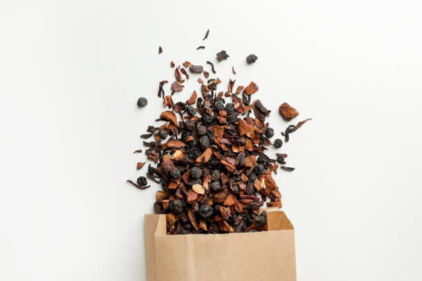 istock Paper bag with scattered dried tea on white background, top view 1461428615