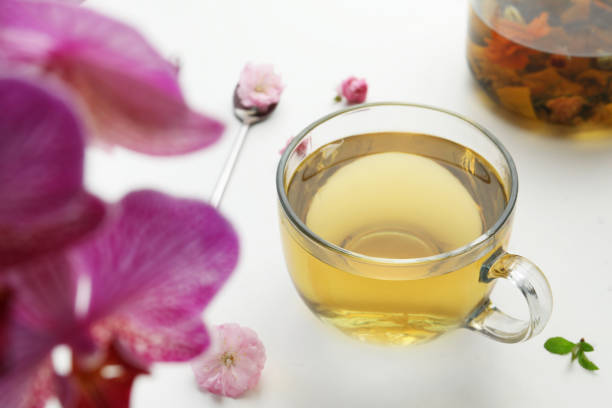 istock Glass cup of freshly brewed tea and flowers on light table 1461428653