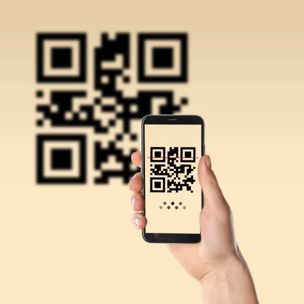 istock Woman scanning QR code with smartphone on beige background, closeup 1461429077