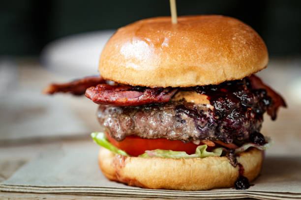 istock Freshly flame grilled bacon cheeseburger on wooden table 1461432435