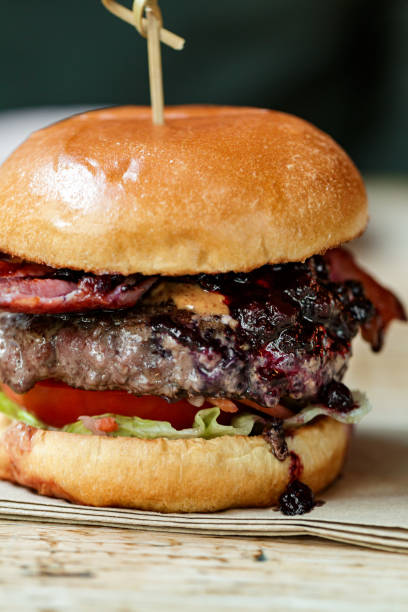 istock Freshly flame grilled bacon cheeseburger on wooden table 1461432442