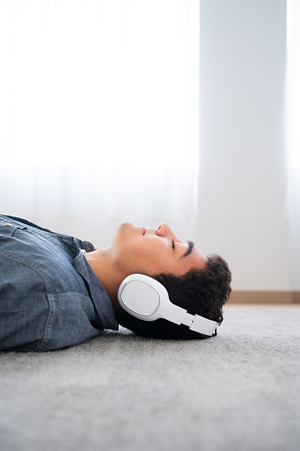 Teenager boy relaxing lying on floor with copy space